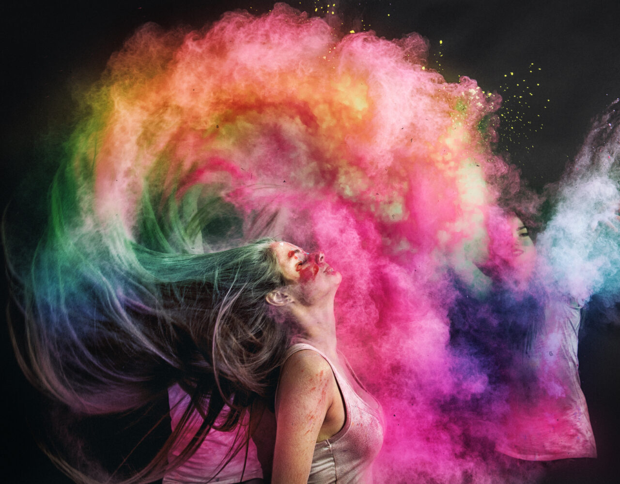 A smiley face with an arrow pointed at it spray painted onto the road with a girls shoes and jeans shown standing beside it.